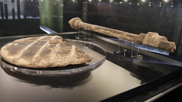 Uma fotografia de uma antiga roda de madeira em uma exposição de museu