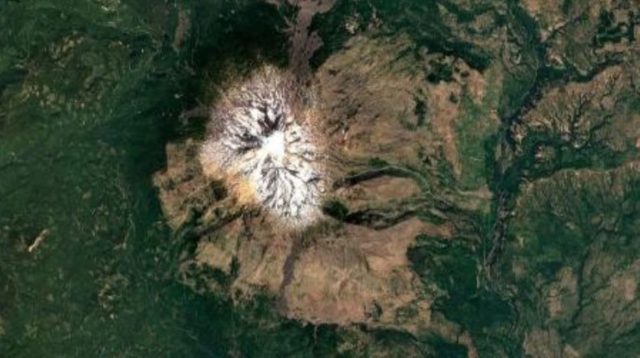 vista aérea do Monte Adams, no estado de Washington, com pico coberto de gelo e vegetação verde ao redor