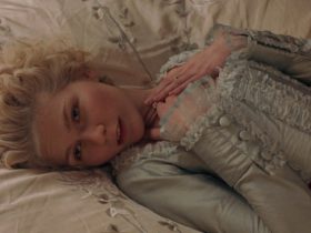 Kirsten Dunst as Marie Antoinette lying on her bed in Marie Antoinette