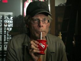 Stephen King as a show owner drinking from a tiny cup in It Chapter Two