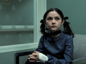 Esther the evil orphan sitting with a cast on her arm in the movie Orphan