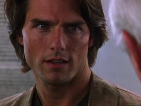 Tom Cruise as Ethan Hunt, long hair, looking intense.