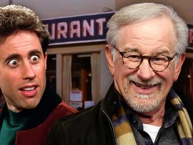 A google eyed Jerry Seinfeld and a grinning Steven Spielberg stand in front of Monk's Cafe