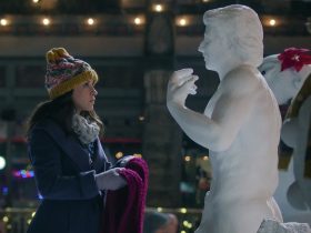 Lacey Chabert as Kathy holding a scarf up to a very buff snowman in Hot Frosty